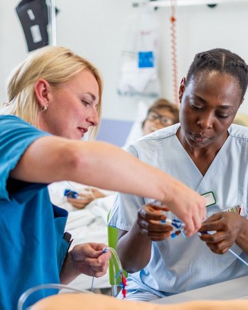 Zwei Krankenschwestern arbeiten zusammen an einem Tisch im Krankenhaus, während sie medizinische Geräte und Materialien überprüfen.